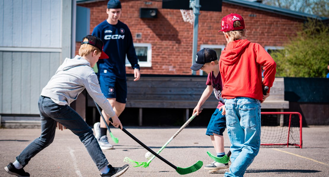 Barn som spelar innebandy på en rast tillsammans med en hockeykille